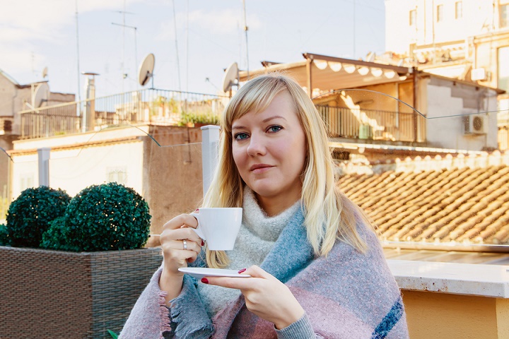 Romantic-woman-enjoying-a-cup-of-coffee-on-a-roof-terrace-in-Rome